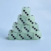 A stack of ten translucent white dice with black dots, used as a glow-in-the-dark dice set.