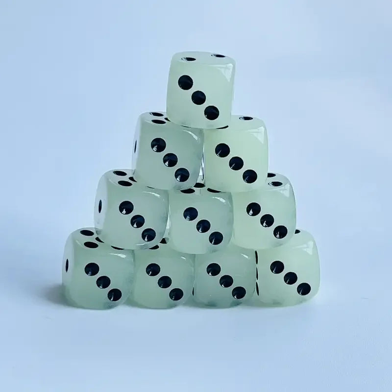 A stack of ten translucent white dice with black dots, used as a glow-in-the-dark dice set.