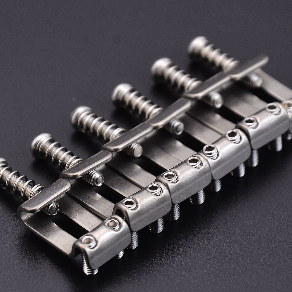 A set of titanium alloy electric guitar bridge saddles for ST models, shown in a close-up view.