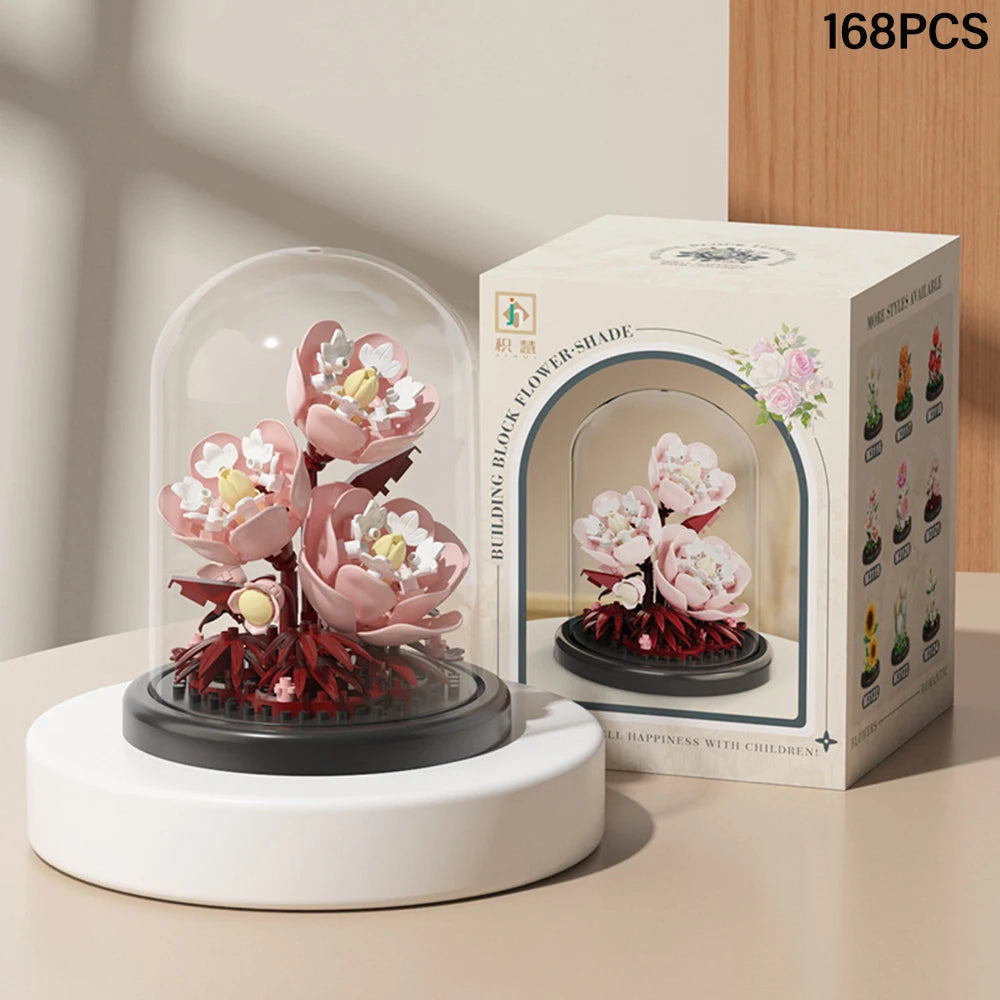 A box of 168 pieces of DIY micro building block eternal flower garden with a dust cover featuring pink blossoms.