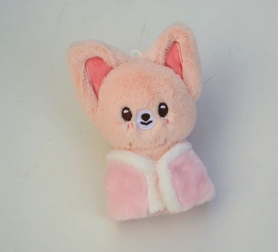 A fluffy pink cartoon animal plush toy with large ears and a light pink bag charm attached.