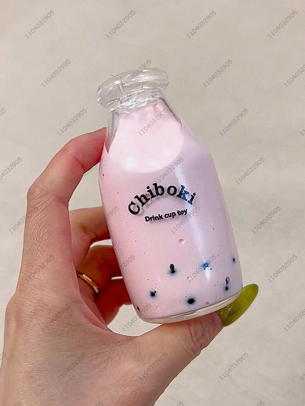 A pink liquid in a glass bottle labeled Chiboki is held by a hand.