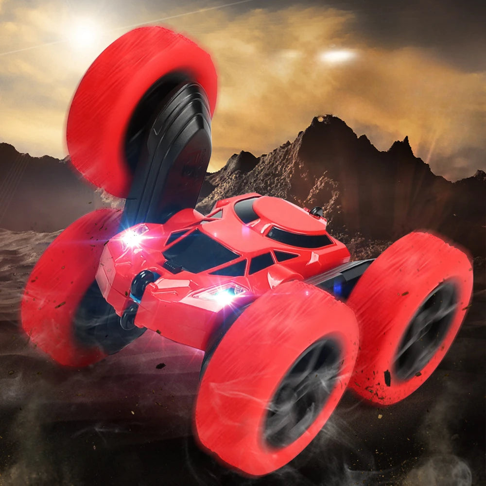 A red RC drift racer car with large tires and LED lights is shown in a dynamic stunt pose against a dark, rugged background.