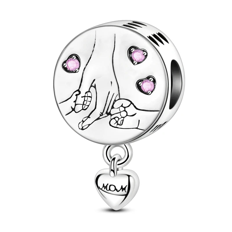 A silver heart charm bead featuring a detailed face design and a small pink zircon gemstone.