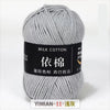 A ball of gray milk cotton yarn with a black label indicating YIMIAN 11 and washing instructions.
