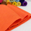 Orange felt fabric sheets rolled up, showing texture and color variation.