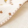 Close-up of a cream colored fabric pillow with brown heart embroidery and a stitched edge.