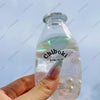 A hand holds a clear plastic bottle filled with liquid and small bubbles, labeled Chiboki, which is a fruit bottle stress bal