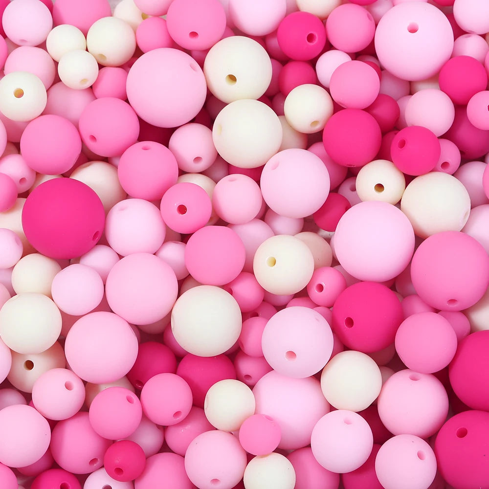 A close-up view of numerous matte acrylic beads in various shades of pink and white.