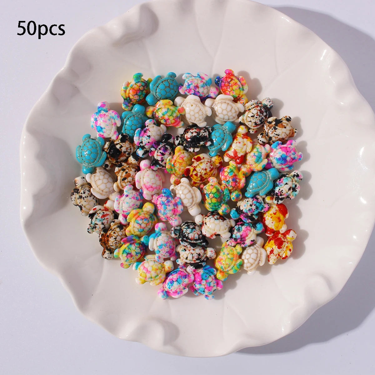 50 pieces of multicolor ocean turtle beads for jewelry making displayed on a white plate