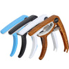 A set of five universal guitar capos in various colors including black white and wood finish