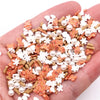 A handful of polymer clay slices in orange, white, and natural wood tones for DIY crafts.