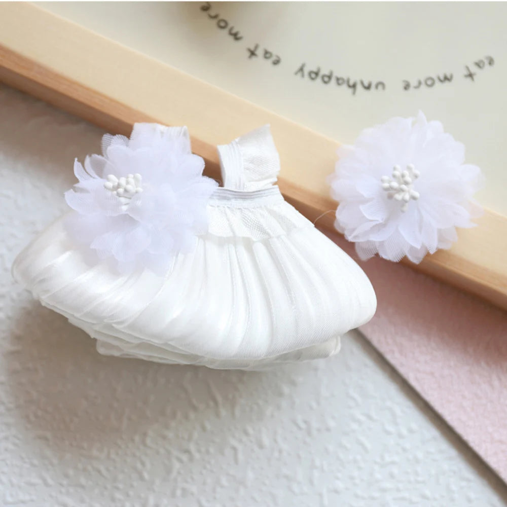A white mini doll wedding dress outfit set featuring a ruffled dress and a large white flower accessory.