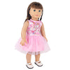 A doll wearing a pink unicorn skirt outfit with a unicorn graphic top and white shoes.