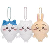Three white plush keychains shaped like cats with blue and peach accents hanging from beaded chains