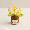 Handmade crochet plant with yellow flowers growing from a brown pot and green leaves