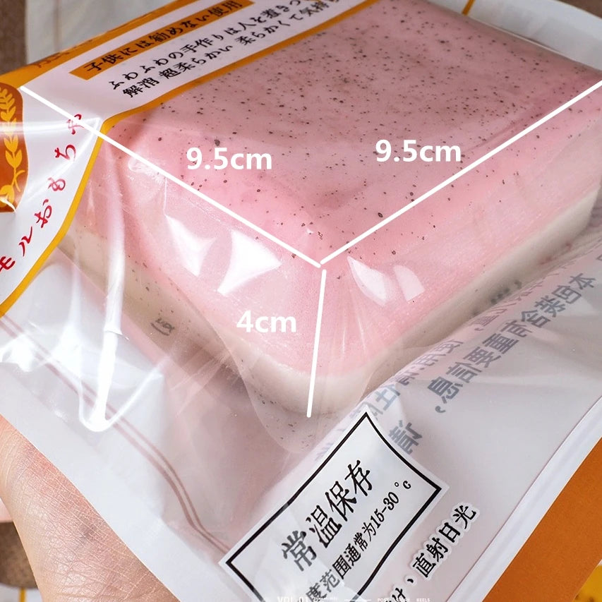 A pink squishy stress relief toy is shown in a clear plastic package, highlighting its dimensions.