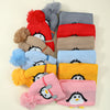 A collection of knitted penguin hats and scarves in various colors including red, gray, blue, yellow, and pink.