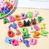 A collection of colorful acrylic alphabet beads arranged on a light background.