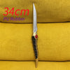A silver PU rubber dagger with a black handle and red accent is displayed on a yellow fabric background.