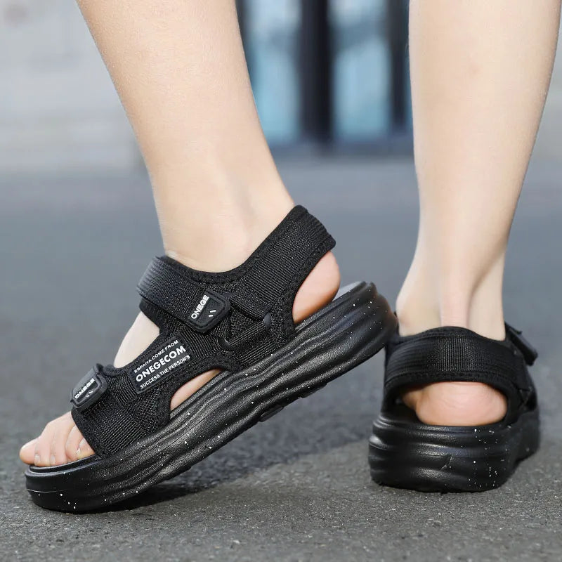 A pair of black non-slip summer sport sandals worn on a person's foot.