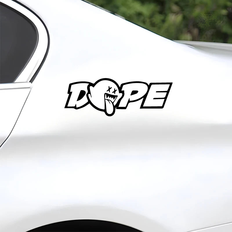 A black and white decal featuring the word DOPE with a tongue gesture on a white car surface.