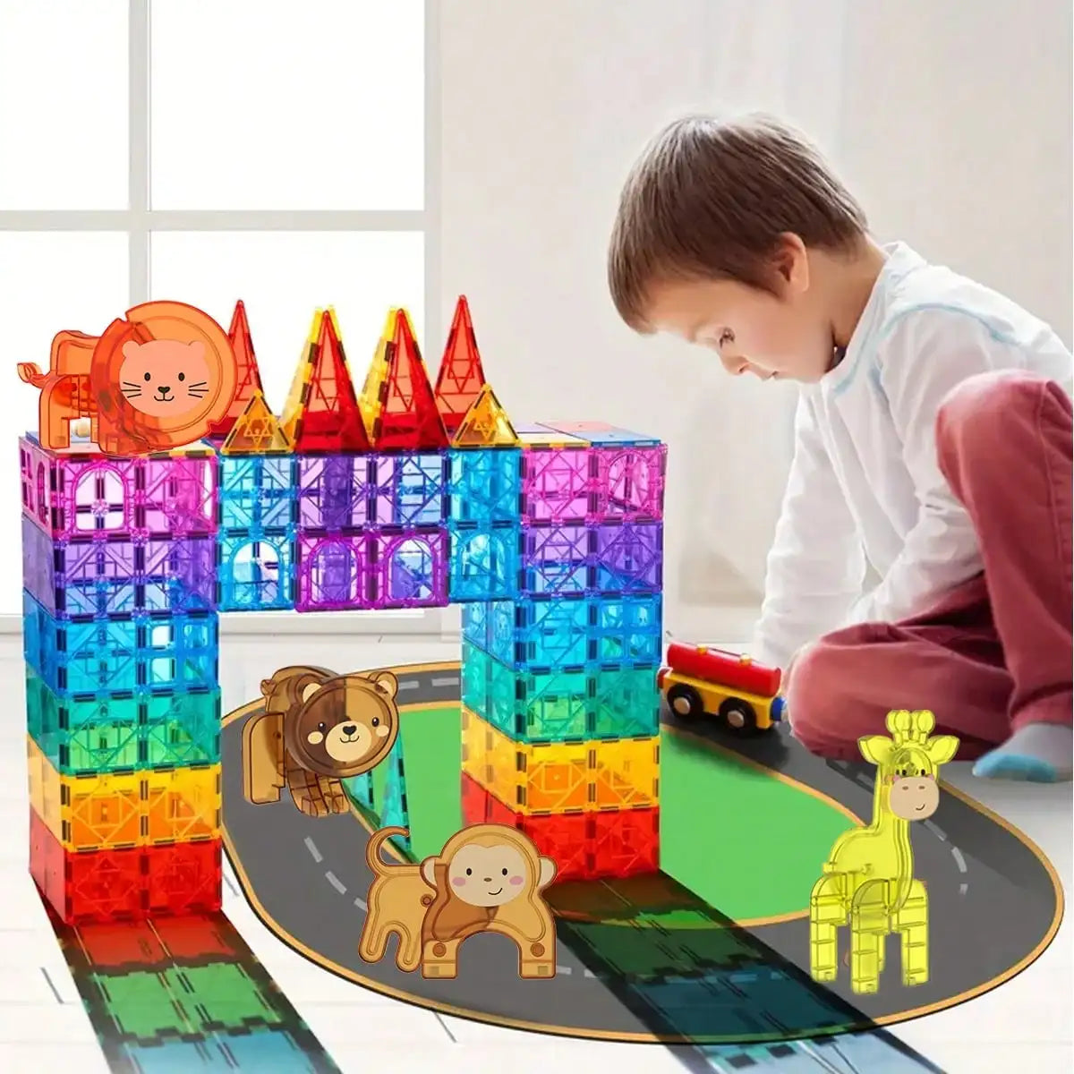 A boy is building a structure with colorful magnetic blocks featuring dinosaur and animal figures.