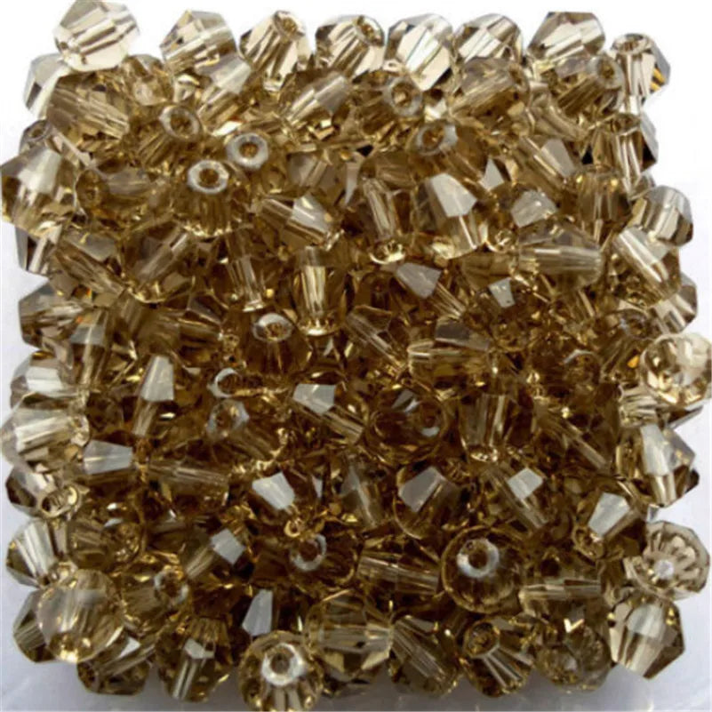 A pile of faceted glass bicone beads used for jewelry making.