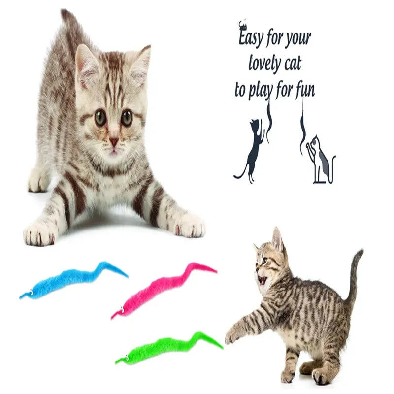 A kitten is playing with a set of magic worm toys on a string.