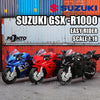 A collection of three Suzuki GSX-R1000 easy rider scale 1:18 die-cast motorcycle models in blue, red, and black.