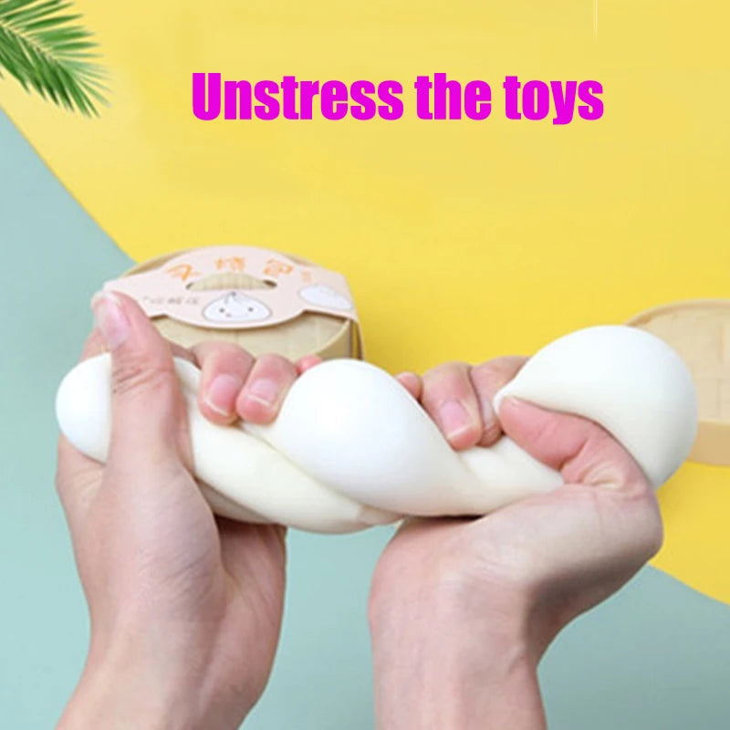 Hands squeezing a white dumpling squishy stress relief toy against a yellow background.