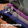 A stack of dark colored t-shirts showing various shades of purple, gray, and blue fabric.