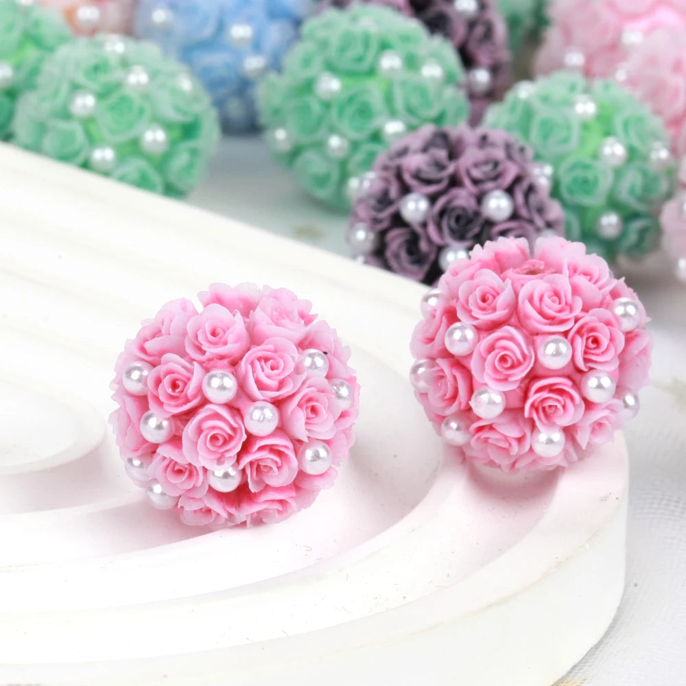 Pink rose flower ball acrylic beads in various shades arranged on a white surface