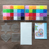 A craft kit showing various colored fuse beads, a star, a circle, a heart, and a square tile.