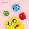 A selection of wooden face-changing cubes in blue, green, and red on a pink background.