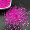 A pile of vibrant magenta crushed glass crystals for resin and jewelry making