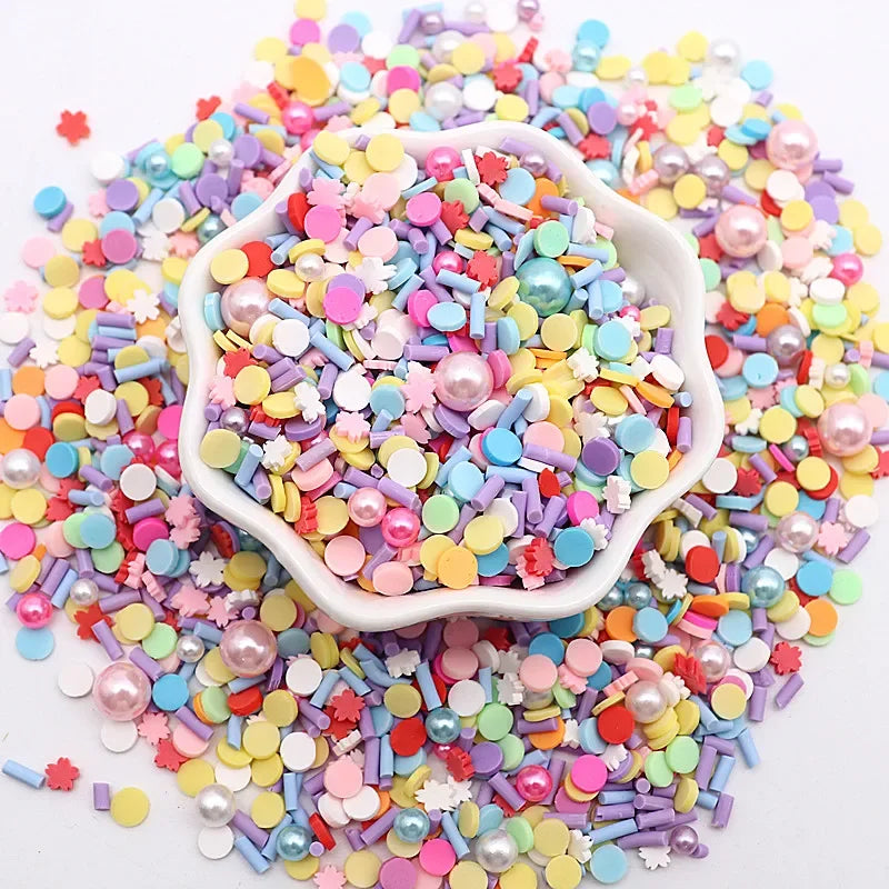 A pile of colorful polymer clay sprinkles mix in various shades of pink, blue, yellow, and green.