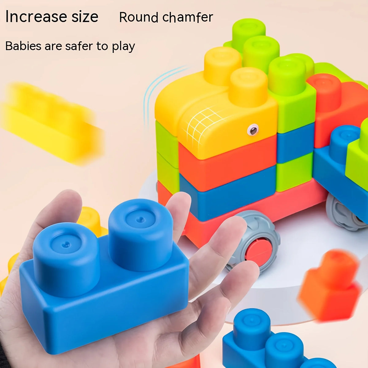 A hand holds a blue rubber building block, with other colorful blocks and a yellow piece visible in the background.
