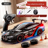 A black four-wheel drive drift car model is shown next to a remote control and various tools on a wooden surface.