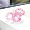 Pink crystal fidget twist rope with a loop design resting on a white surface.