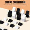A collection of black and white geometric 3D blocks, including trapezoids and triangles, arranged on a light surface.