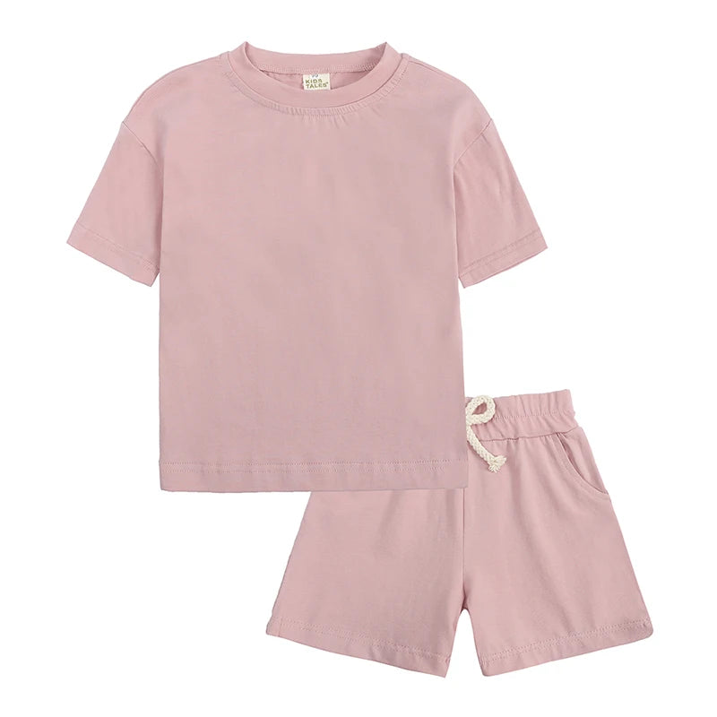 A pink kids summer tracksuit set featuring a short sleeve top and matching shorts.