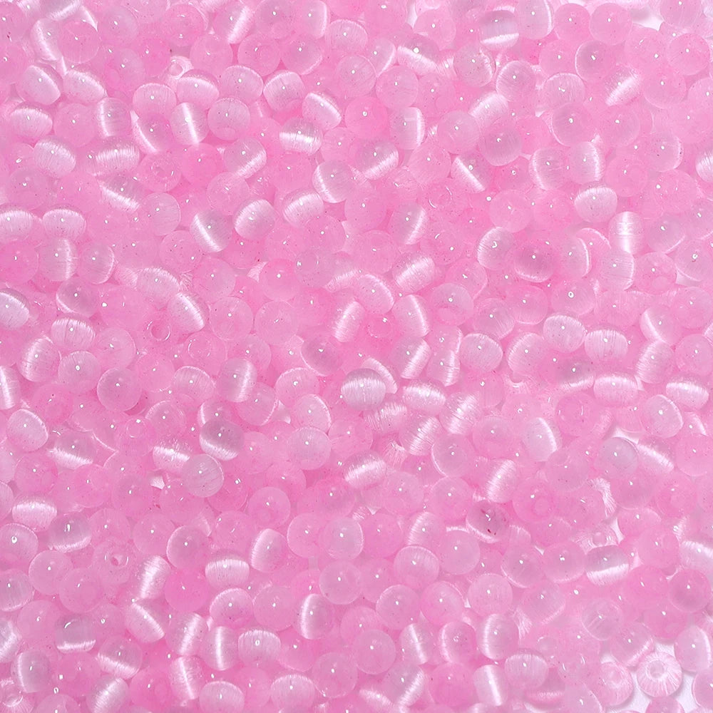 A close-up view of a colorful mix of pink glass beads for jewelry making