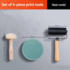 A set of four-piece print tools including a wooden block, a rubber pad, and a roller, displayed on a gray surface.
