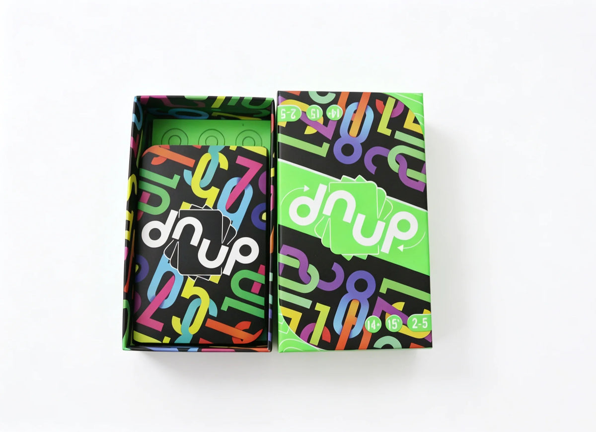 Une boîte du jeu de cartes Dnup avec des motifs abstraits colorés sur l'emballage.