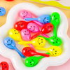 A collection of colorful mini maracas shaker toys in various bright colors are displayed in a white dish.