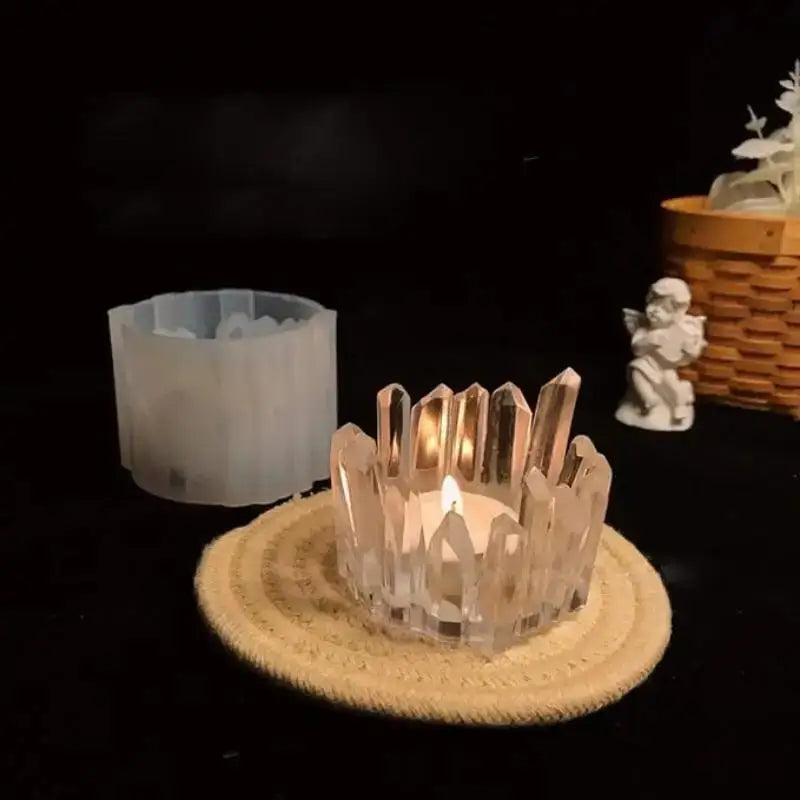 A clear crystal silicone candle mold sits on a woven mat with a lit candle in a dark setting.