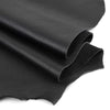 Black cowhide leather fabric folded and draped, showing a smooth texture.