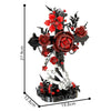 A black skeleton hand cross decoration featuring red roses and dark accents.