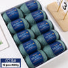 A box of 10 skeins of YEDAN MERINO worsted wool thread yarn in various shades of green and blue.